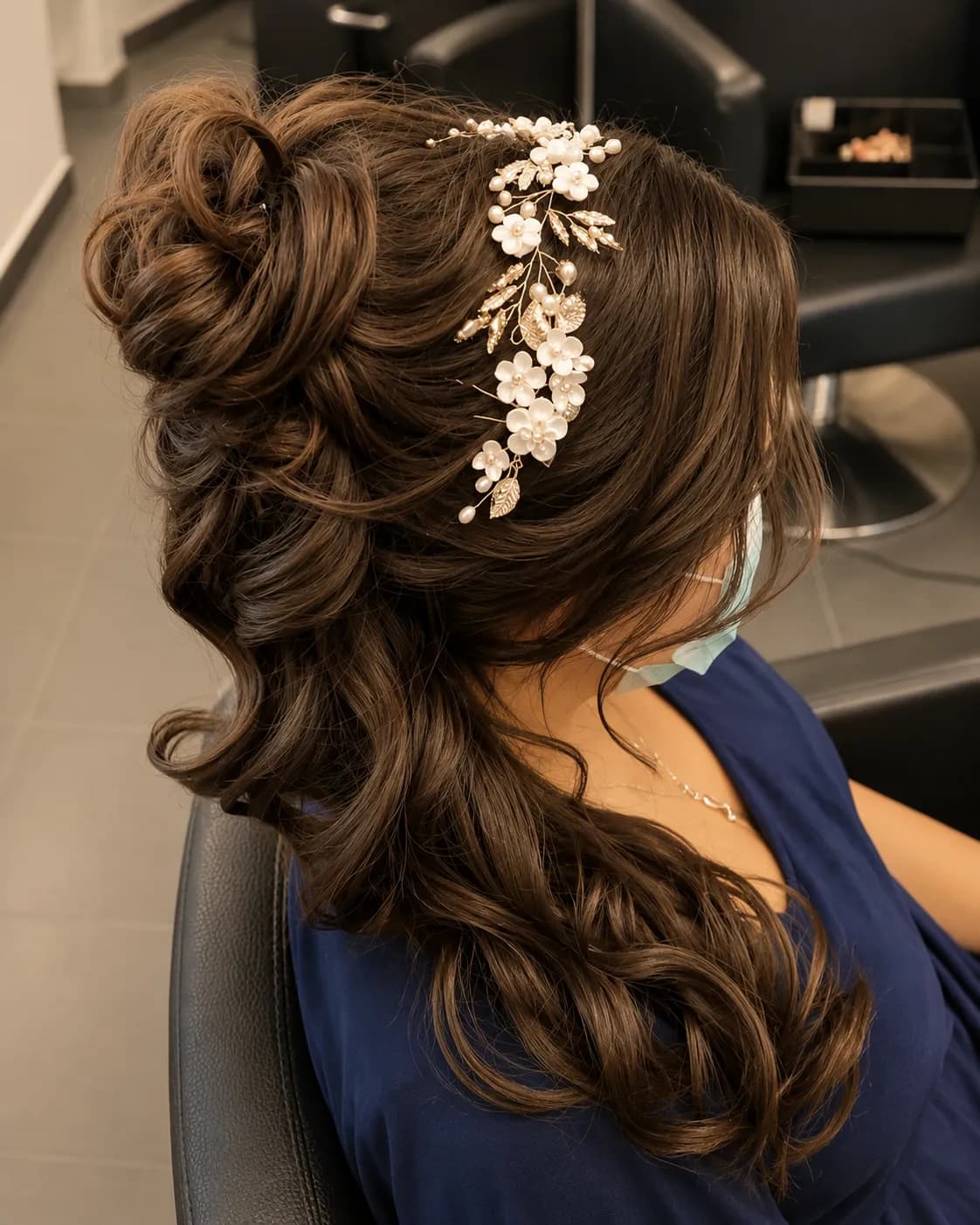Elegante Hochsteckfrisur mit floralen Haarnadeln und langen Locken